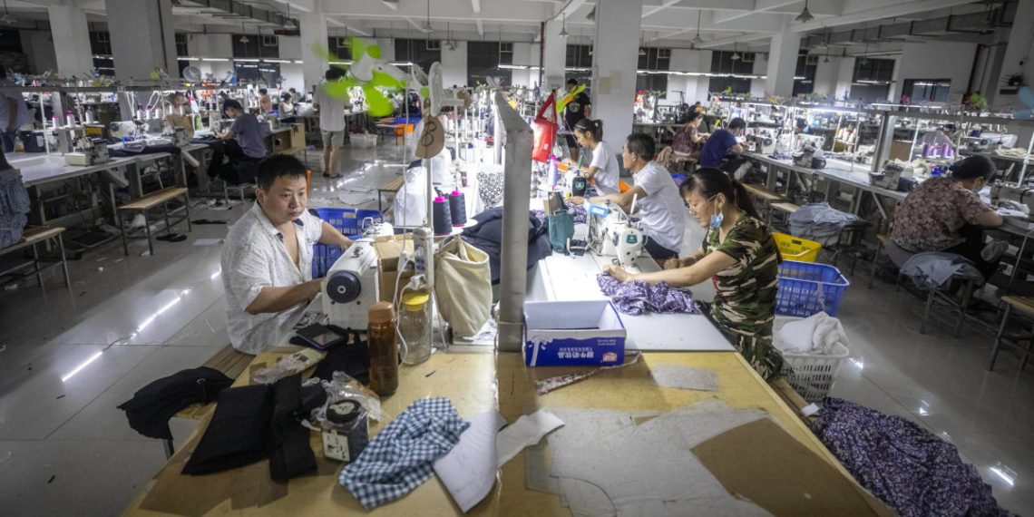 Operai cinesi al lavoro in una fabbrica di abbigliamento a Guangzhou