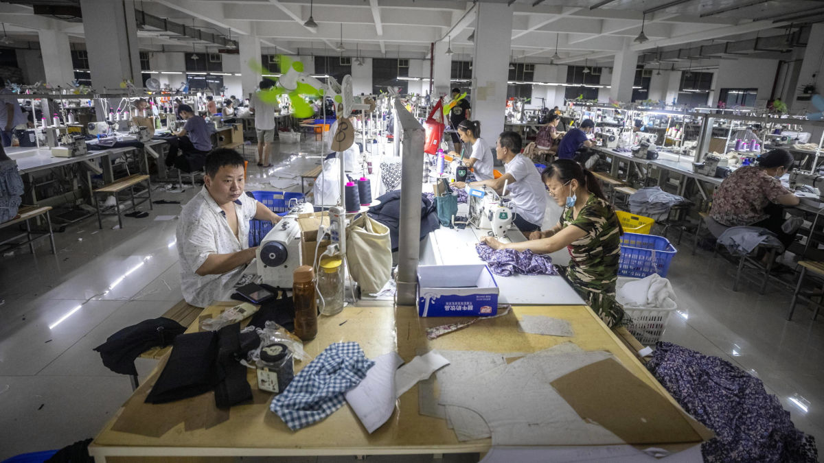 Operai cinesi al lavoro in una fabbrica di abbigliamento a Guangzhou
