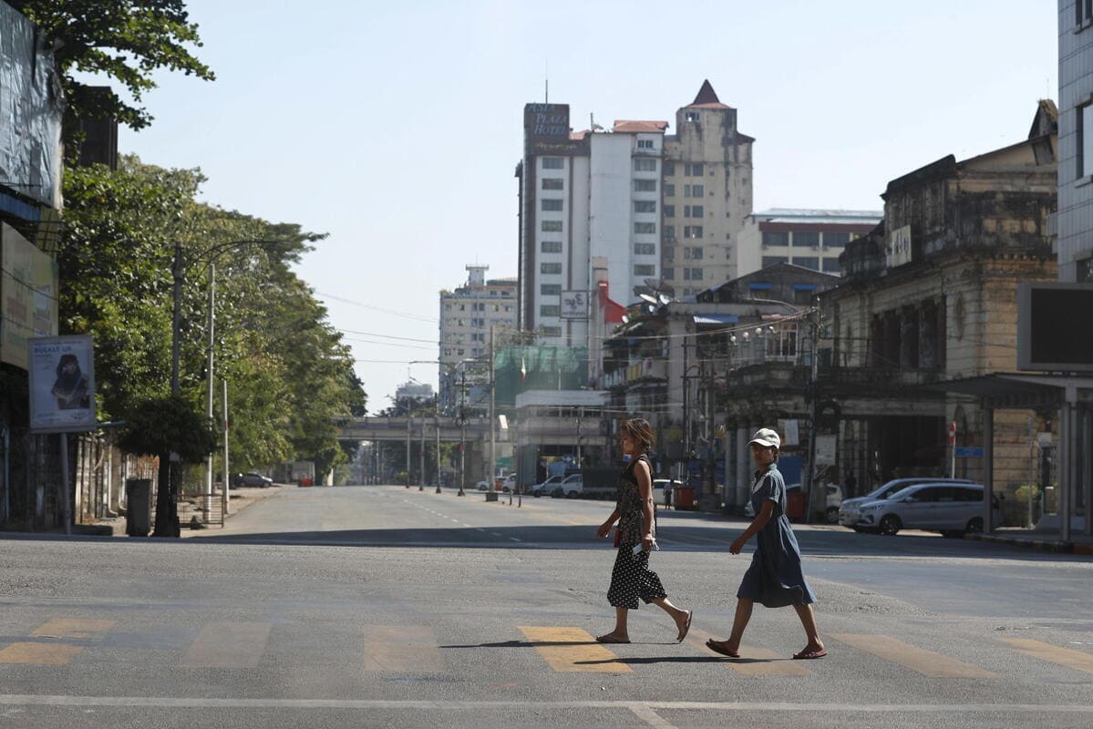 Due ragazze attraversano le strade deserte di Yangon, in Myanmar