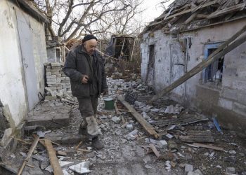 Un uomo passeggia in un villaggio colpito dai bombardamenti dei separatisti in Ucraina