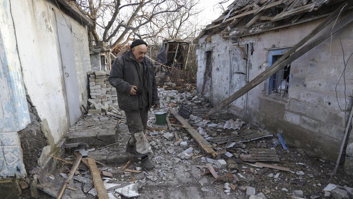 Un uomo passeggia in un villaggio colpito dai bombardamenti dei separatisti in Ucraina