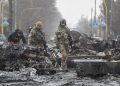 Soldati ucraini tra veicoli militari russi distrutti a Bucha