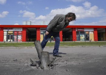 Un uomo osserva i resti di un missile dopo un bombardamento russo su Kharkiv, Ucraina