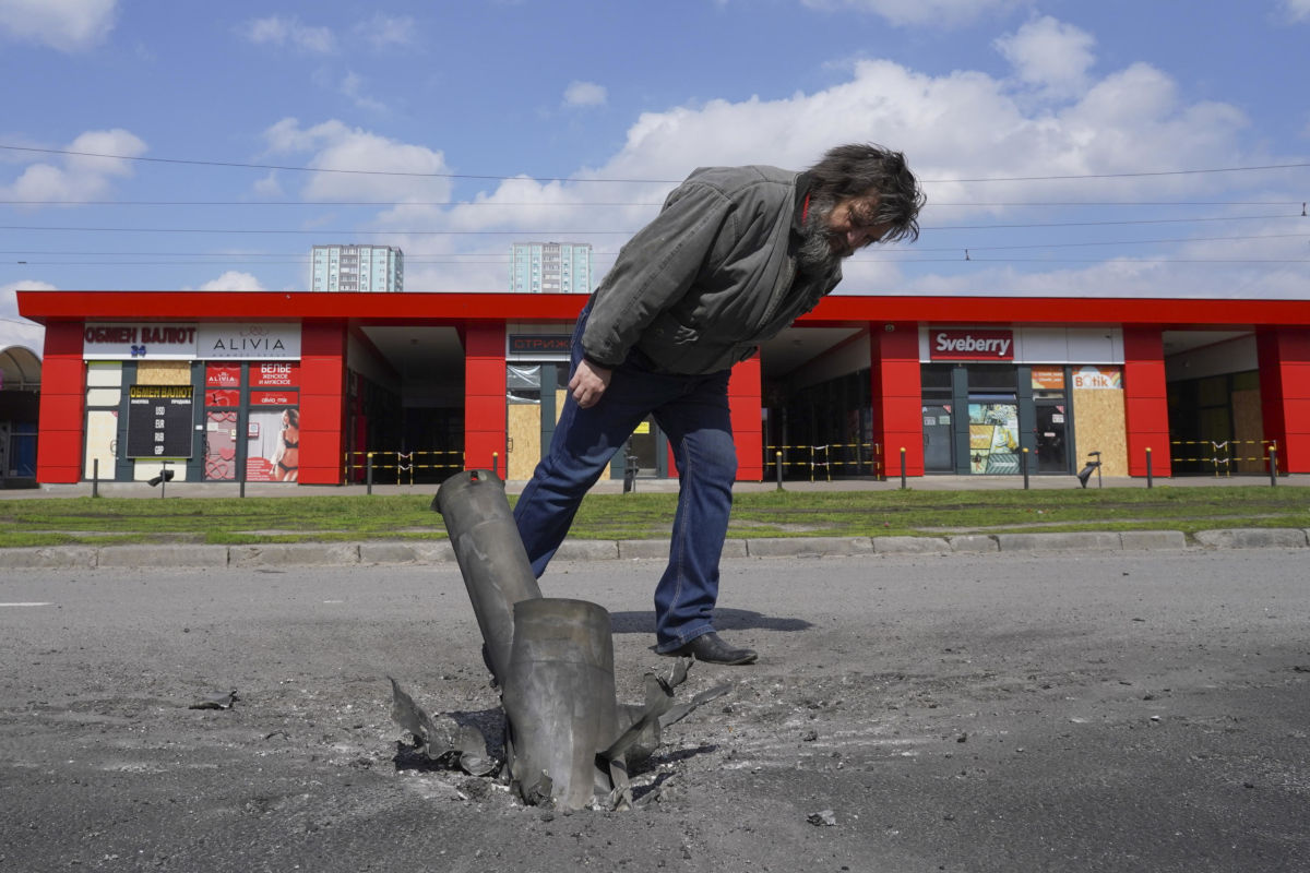 Un uomo osserva i resti di un missile dopo un bombardamento russo su Kharkiv, Ucraina