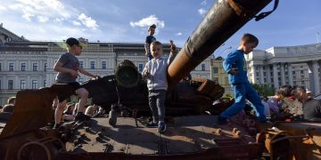Bambini giocano con un carro armato russo in Ucraina