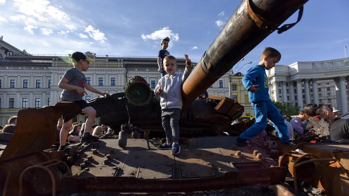 Bambini giocano con un carro armato russo in Ucraina