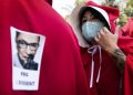 Manifestazione delle “ancelle” dell'aborto, sui mantelli gli adesivi del giudice Ruth Bader Ginsburg, voce progressista della Corte Suprema (foto Ansa)