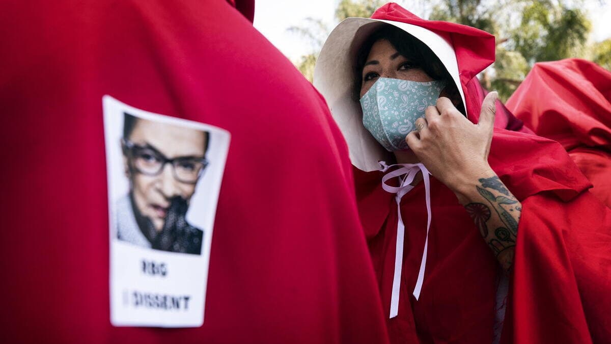 Manifestazione delle “ancelle” dell'aborto, sui mantelli gli adesivi del giudice Ruth Bader Ginsburg, voce progressista della Corte Suprema (foto Ansa)