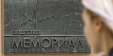 Una donna davanti alla sede di Memorial a Mosca, in Russia