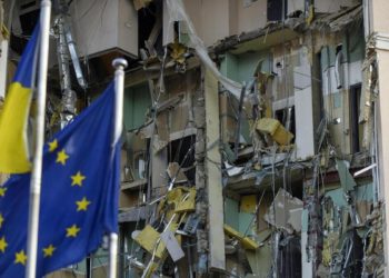 Bandiere di Ucraina e Unione Europea sventolano a Kiev di fianco a un edificio danneggiato dai missili russi
