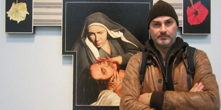 L’artista Federico Guida, sullo sfondo l’opera Croce#6