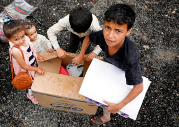 Bambini intorno a uno scatolone di aiuti umanitari a Sana'a, Yemen