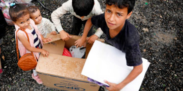 Bambini intorno a uno scatolone di aiuti umanitari a Sana'a, Yemen