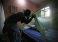 Una donna in Africa installa una zanzariera sul letto del figlio per proteggerlo dalla malaria