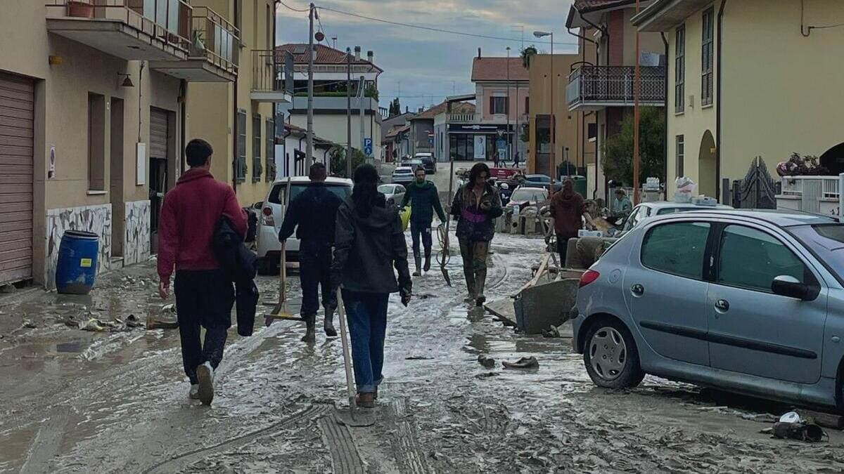 Volontari a Cesena aiutano a ripulire le strade dal fango dopo l'alluvione in Emilia-Romagna