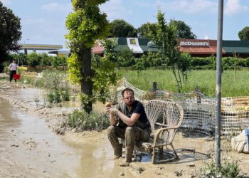 Un ragazzo durante un momento di riposo dal lavoro di ripulitura dopo l'alluvione che ha colpito Forlì, 22 maggio 2023 (Ansa)