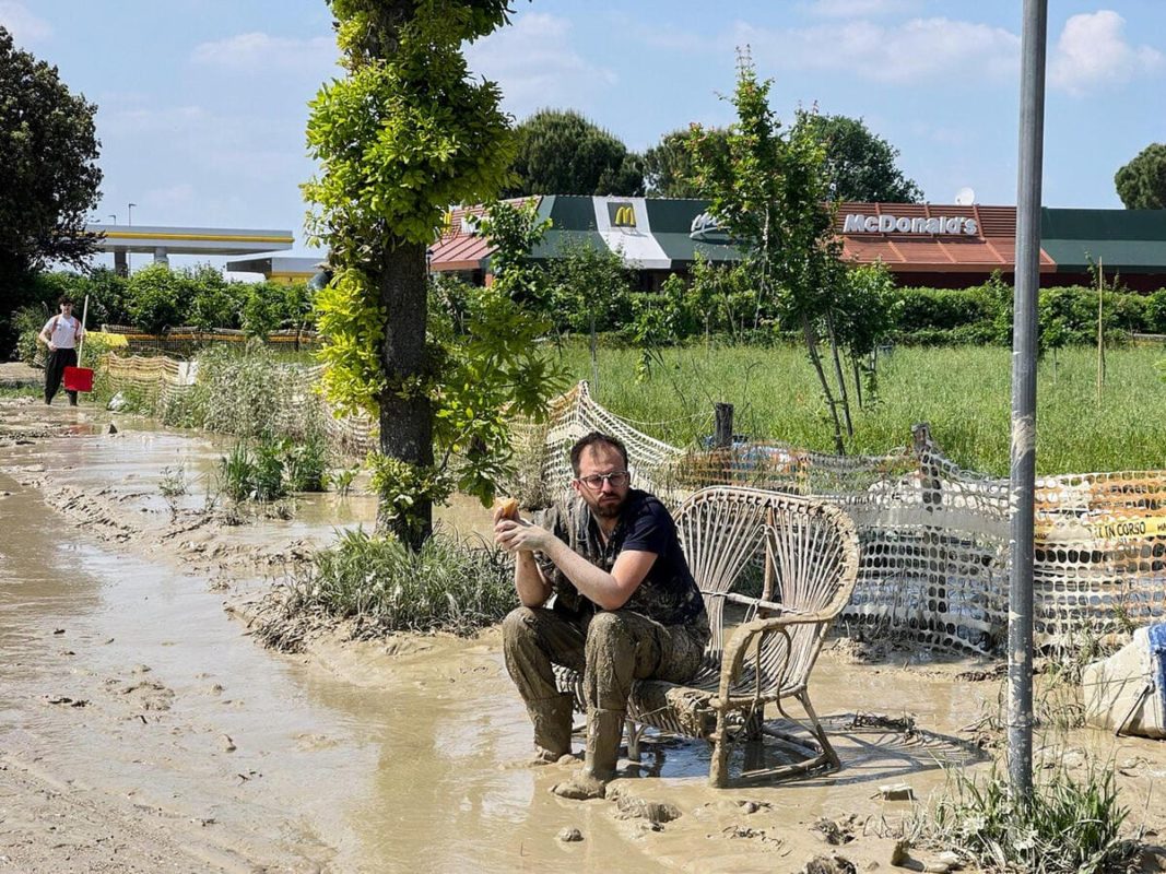 Un ragazzo durante un momento di riposo dal lavoro di ripulitura dopo l'alluvione che ha colpito Forlì, 22 maggio 2023 (Ansa)