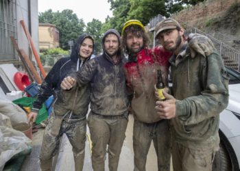 Volontari arrivati da Bologna aiutano a pulire le strade allagate a Faenza, 19 maggio 2023 (Ansa)