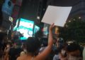Una giovane ragazza protesta con un foglio bianco contro la censura a Hong Kong