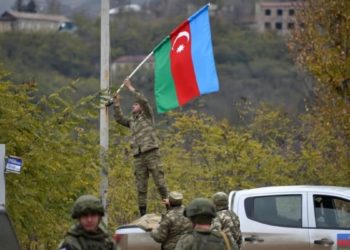 Un soldato azero cerca di issare la bandiera dell'Azerbaigian in Armenia
