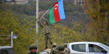 Un soldato azero cerca di issare la bandiera dell'Azerbaigian in Armenia