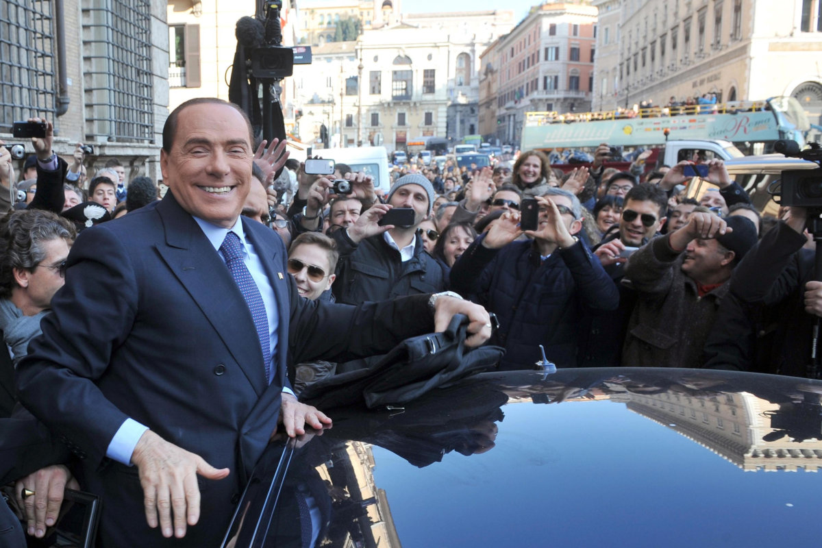 Silvio Berlusconi saluta i suoi fan salendo sul predellino dell’auto