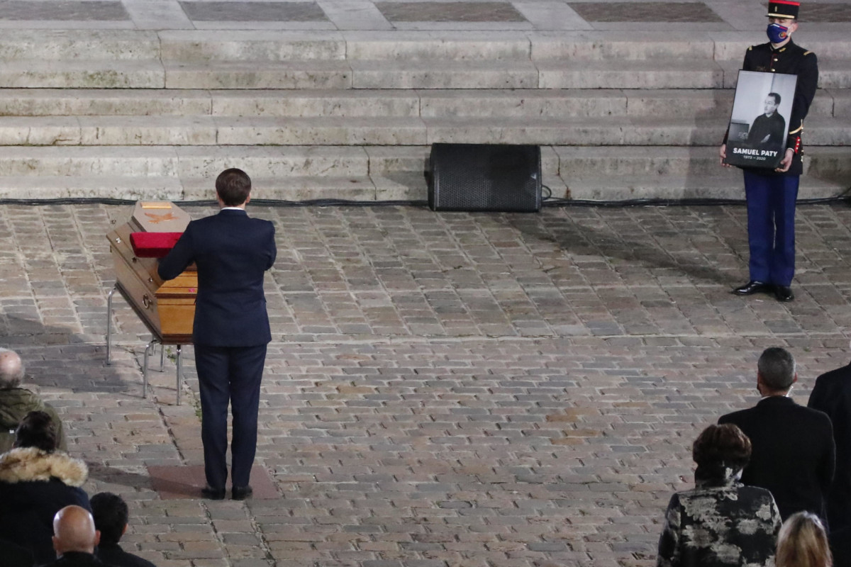 Emmanuel Macron rende omaggio alla salma di Samuel Paty durante la pubblica cerimonia di commemorazione nel cortile della Sorbona