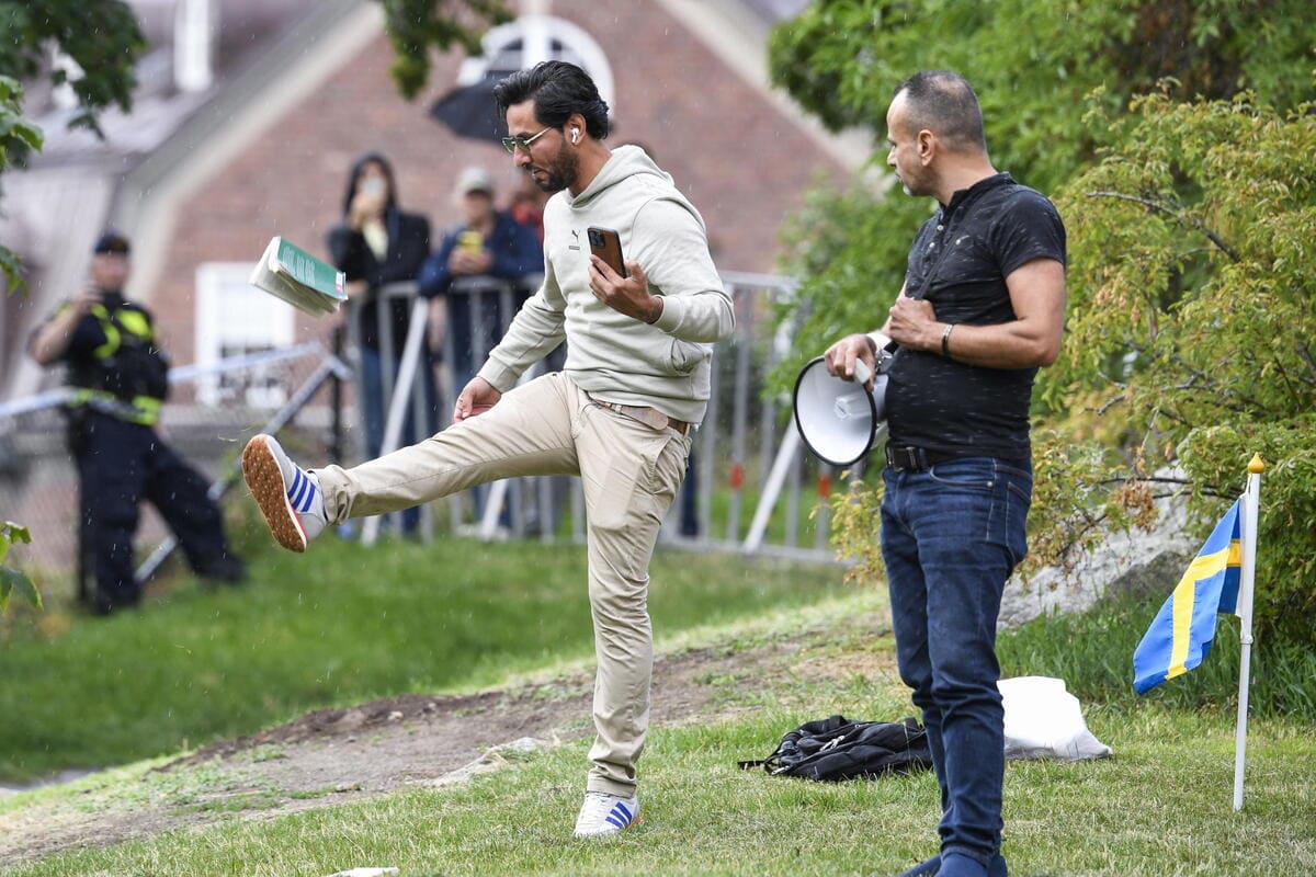 Salwan Momika colpisce una copia del Corano durante una manifestazione davanti all'ambasciata irachena a Stoccolma, 20 luglio 2023 (Ansa)