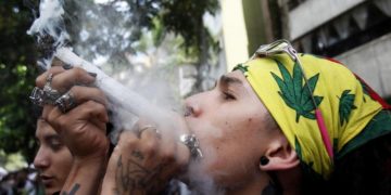 Un ragazzo fuma cannabis in Colombia durante una marcia a favore della legalizzazione della droga