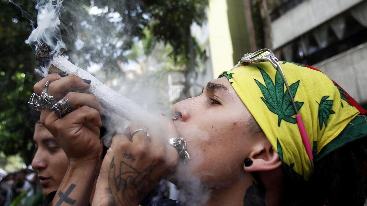 Un ragazzo fuma cannabis in Colombia durante una marcia a favore della legalizzazione della droga