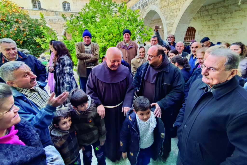 Padre Hanna Jallouf tra i cristiani rimasti con lui a Knayeh, in Siria, nonostante i soprusi da parte dei jihadisti