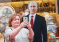Selfie con la sagoma in cartone di Vladimir Putin, Mosca, 28 giugno 2023 (foto Ansa)