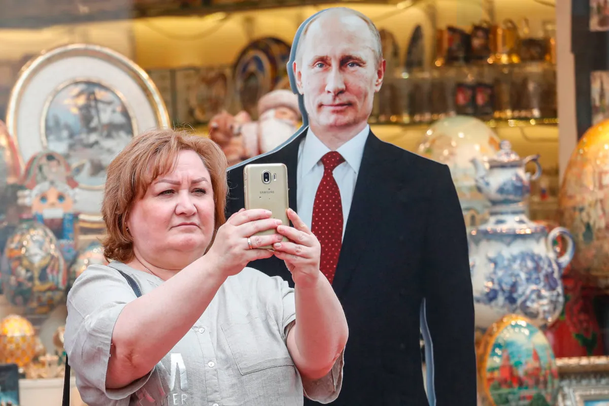 Selfie con la sagoma in cartone di Vladimir Putin, Mosca, 28 giugno 2023 (foto Ansa)