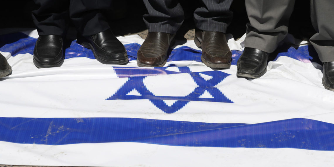 Una bandiera di Israele calpestata durante una manifestazione in Yemen in sostegno all’attacco armato di Hamas
