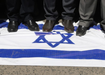 Una bandiera di Israele calpestata durante una manifestazione in Yemen in sostegno all’attacco armato di Hamas