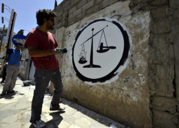 Il graffito realizzato da un artista durante un evento contro la corruzione a Sanaa, Yemen