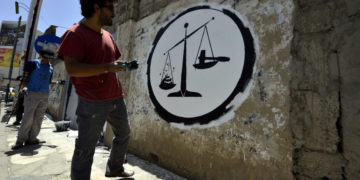 Il graffito realizzato da un artista durante un evento contro la corruzione a Sanaa, Yemen