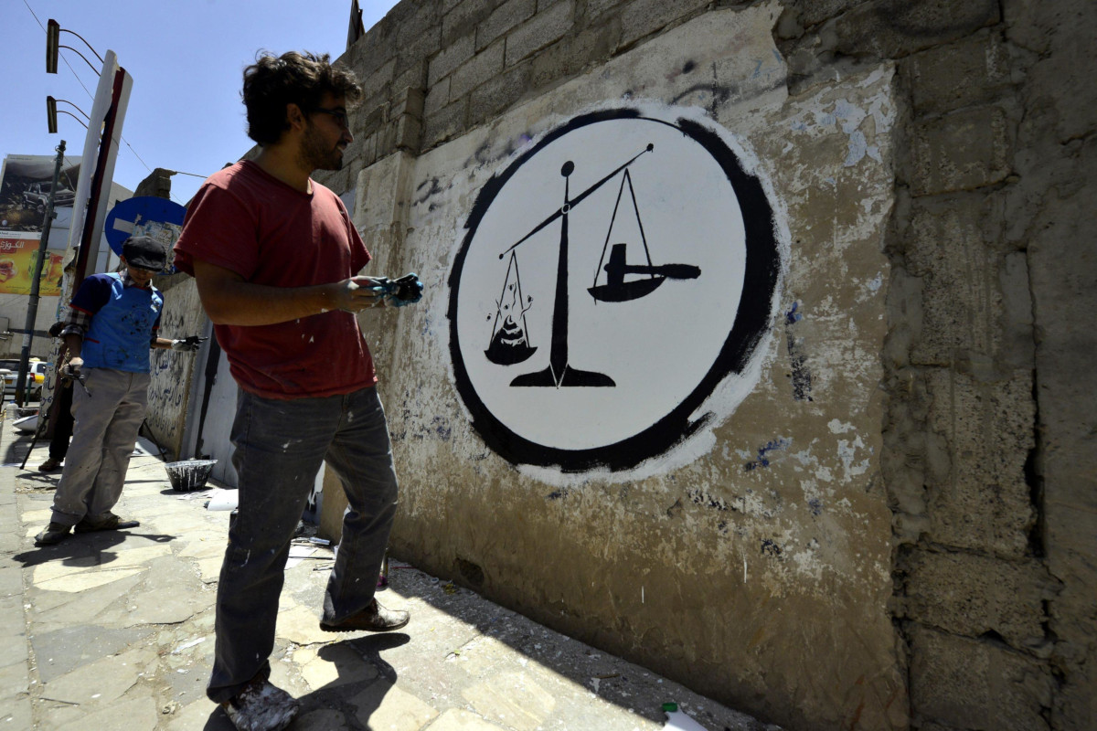 Il graffito realizzato da un artista durante un evento contro la corruzione a Sanaa, Yemen