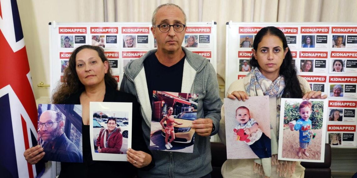 Parenti degli ostaggi israeliani, tengono fotografie dei propri cari e delle vittime di Hamas, il 24 ottobre 2023 (Ansa)