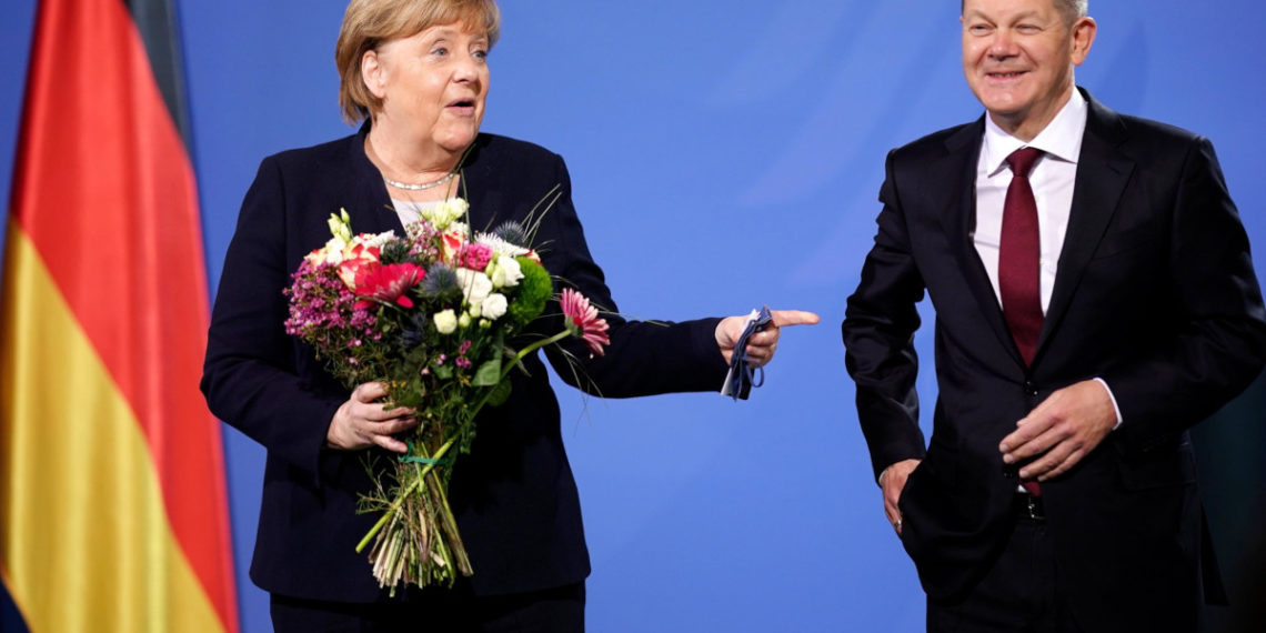 Il passaggio di consegne tra l’allora cancelliera tedesca Angela Merkel e il successore Olaf Scholz, 8 dicembre 2021