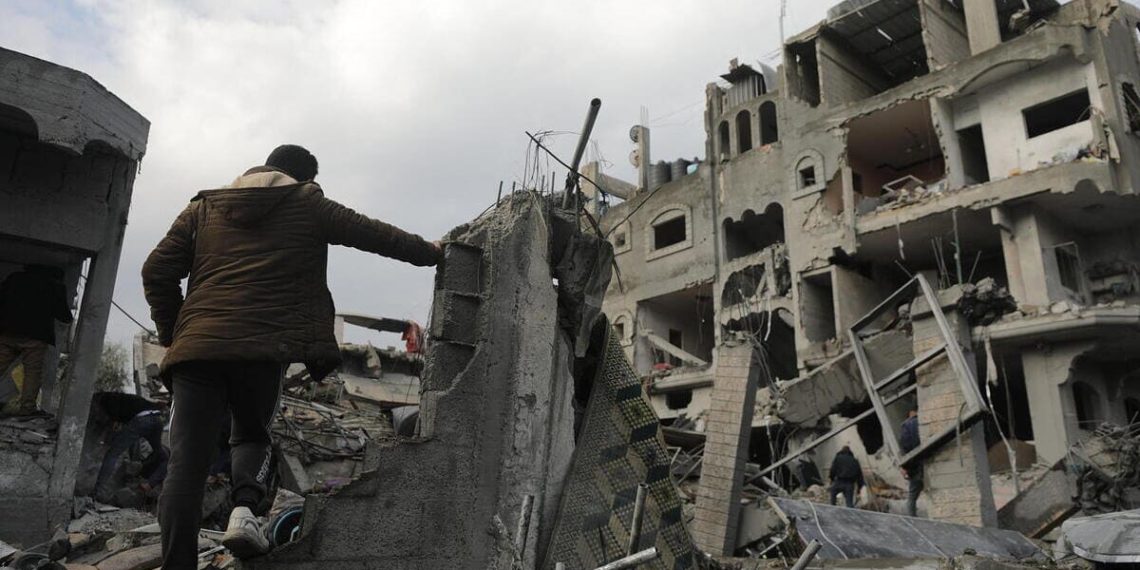 Un palestinese cammina tra i palazzi distrutti da un raid israeliano nel sud della Striscia di Gaza