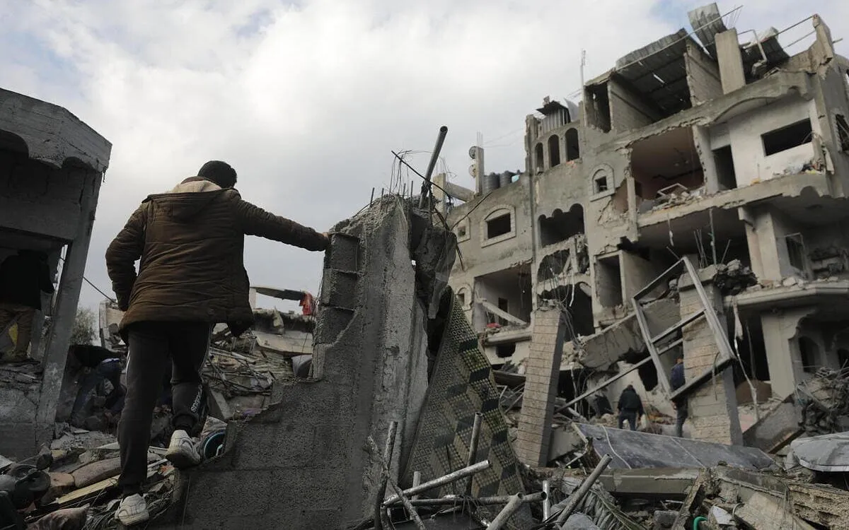 Un palestinese cammina tra i palazzi distrutti da un raid israeliano nel sud della Striscia di Gaza