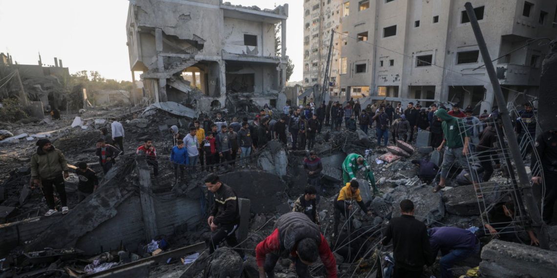 Palestinesi in cerca di sopravvissuti tra le macerie dopo un bombardamento israeliano ad Al Nusairat, nella Striscia di Gaza, 20 febbraio 2024