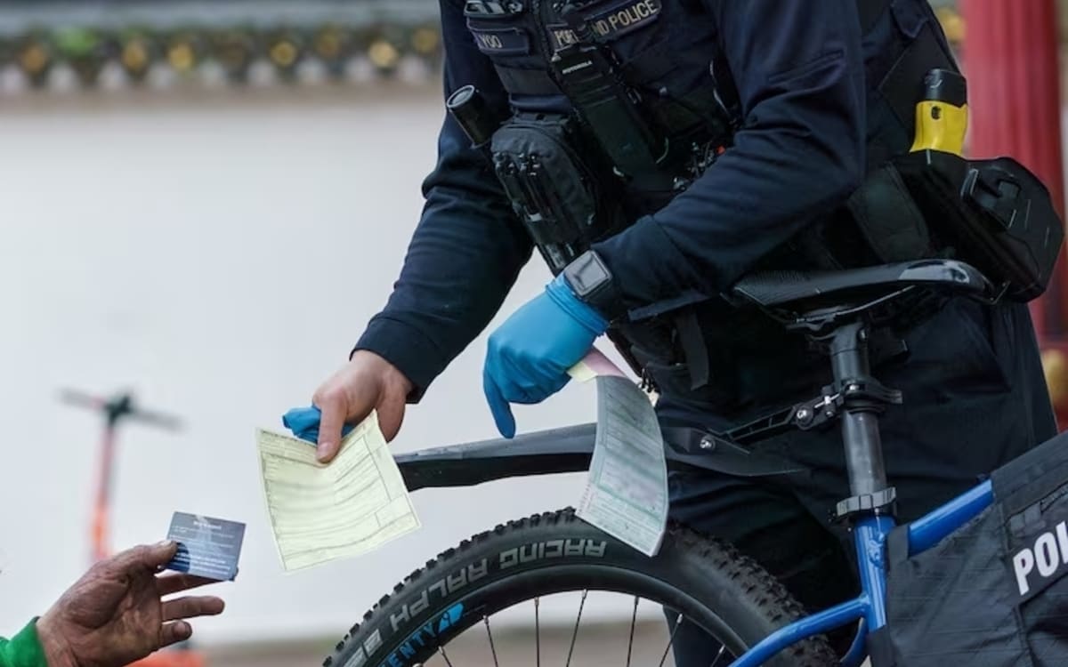 Un poliziotto consegna a un tossicodipendente la multa da 100 dollari e il numero da chiamare per il percorso terapeutico a Portland, Oregon