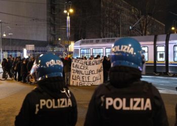 Antagonisti in corteo dopo aver assaltato un auto della polizia davanti alla questura di Torino, 28 febbraio 2024 (Ansa)