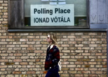 Una donna davanti a un seggio di Dublino durante i referendum dell’8 marzo per modificare la Costituzione d’Irlanda (foto Ansa)