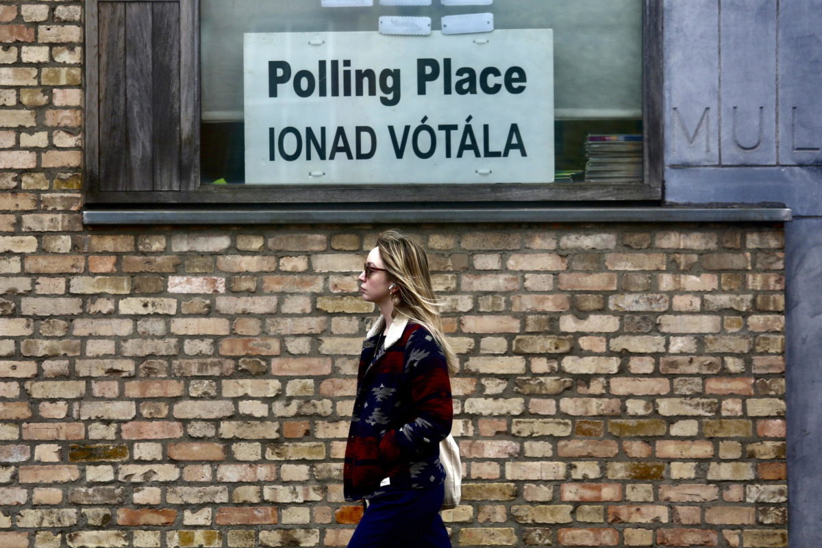 Una donna davanti a un seggio di Dublino durante i referendum dell’8 marzo per modificare la Costituzione d’Irlanda (foto Ansa) 