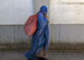 Una donna coperta dal burqa per le strade di Kabul, Afghanistan, agosto 2023