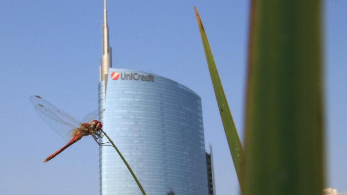 Libellula su filo d'erba davanti al grattacielo Unicredit a Milano (Ansa)
