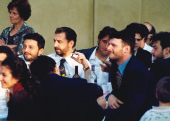 Enzo Piccinini (1951-1999) con il sigaro in mano e intorno gli amici in occasione di una festa di matrimonio